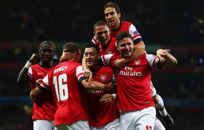 Özil, abrazado por sus compañeros tras marcar al Nápoles.