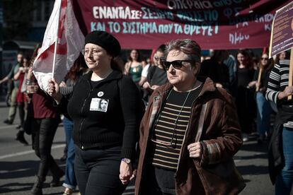 Una mujer sostiene a su madre de la mano mientras participan en una marcha por el Día Internacional de la Mujer, el 8 de marzo de 2019, en Atenas (Grecia).