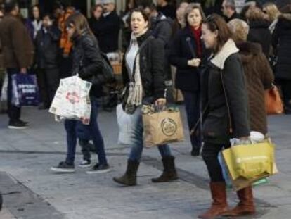 Varias mujeres pasean por la calle Preciados de Madrid tras realizar algunas compras en los establecimientos de la zona, con motivo de las fiestas navide?as.