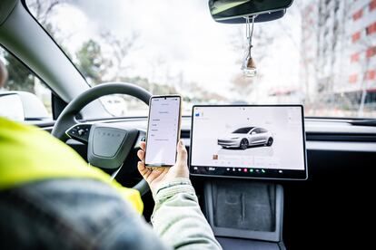 Una usuaria de un coche eléctrico solicita asistencia a su seguro a través de una aplicación móvil.