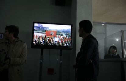 Un hombre mira la televisión norcoreana, que emite uno de los desfiles multitudinarios, con el rostro del fundador de Corea del Norte, Kim Il Sung, icono continúo de la propaganda de Pyongyang.