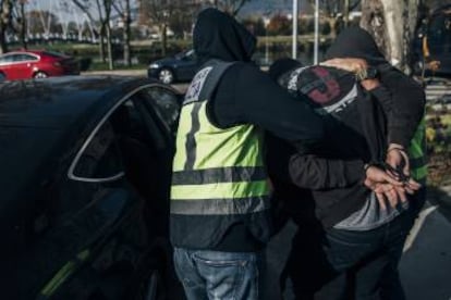 Imágenes de la Operación Poseidón. Arriba, un furgón de la policía bloquea la calle donde está el chalé asaltado. Abajo, la policía introduce a un detenido en un coche.