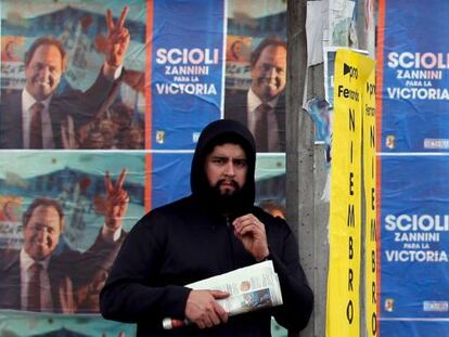 Un hombre espera el autob&uacute;s frente a la propaganda de Scioli. 