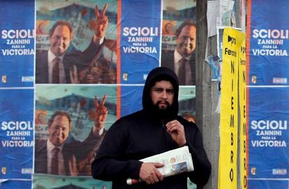 Un hombre espera el autob&uacute;s frente a la propaganda de Scioli. 
