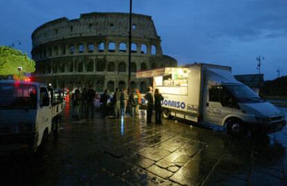 Un grupo de ciudadanos, ayer al amanecer, frente al Coliseo, mientras Roma continuaba afectada por el apagón eléctrico.