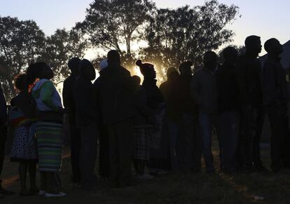 La gente espera en una fila para emitir su voto en una mesa electoral, en Harare.