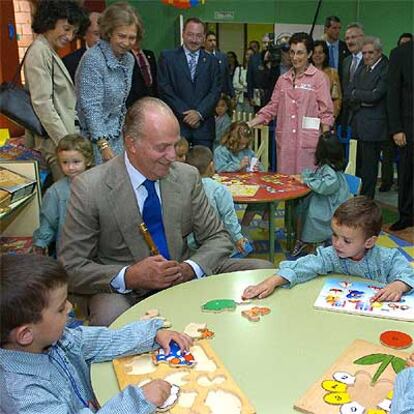 Juan Carlos I saluda a varios niños durante la visita al colegio público de infantil y primaria Enrique Alonso de Avilés.