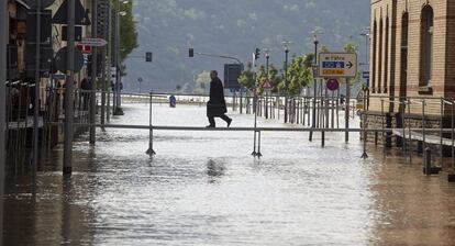 Un hombre cruza una calle inundada en St. Goarshausen (Alemania) hoy, martes 4 de junio de 2013.