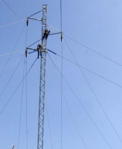 Los operarios de una compa&ntilde;&iacute;a el&eacute;ctrica reparan una torre de alta tensi&oacute;n.