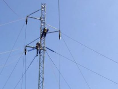 Los operarios de una compa&ntilde;&iacute;a el&eacute;ctrica reparan una torre de alta tensi&oacute;n.