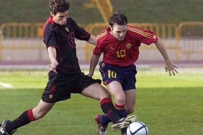 Andrés Iniesta (dcha.) controla el balón ante el belga Colinet, durante el partido jugado hoy por ambos equipos en el campo de La Maruca (Cantabria).