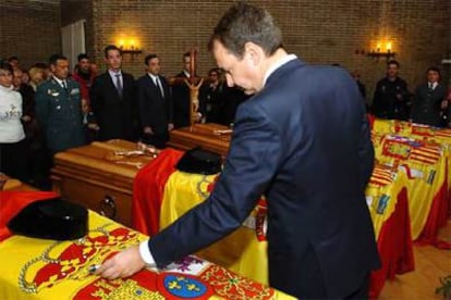 Zapatero coloca la medalla al mérito civil en los cinco féretros en el tanatorio de Colmenar Viejo.