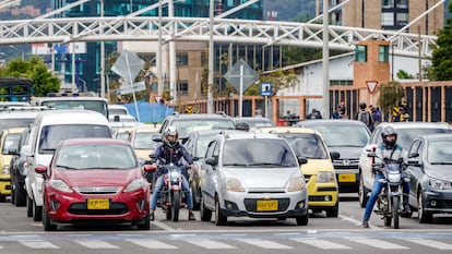 Automovilistas y motociclistas esperan en un cruce en Bogotá.