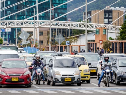 Automovilistas y motociclistas esperan en un cruce en Bogotá.