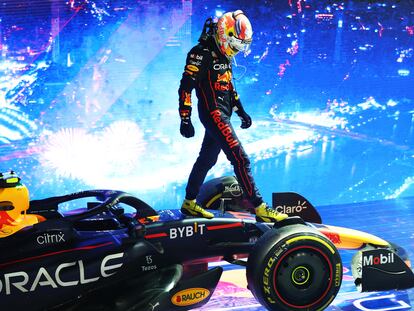 Checo Pérez camina sobre su Red Bull tras ganar el Gran Premio de Singapur.