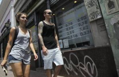 Una pareja camina frente a la entrada a una casa de cambio este lunes 20 de enero de 2014, en el centro de Buenos Aires (Argentina).