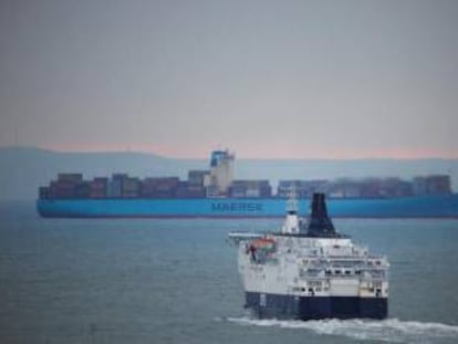Ferry DFDS en primer plano y barco contenedor de Maersk al fondo, en Dover (Reino Unido).