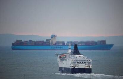 Ferry DFDS en primer plano y barco contenedor de Maersk al fondo, en Dover (Reino Unido).