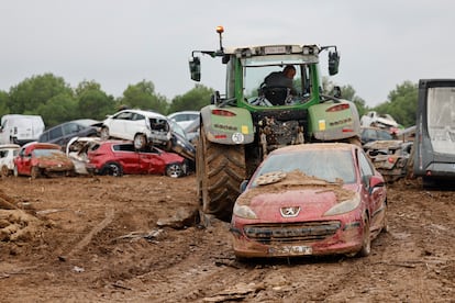 A tractor works in an improvised scrap yard in an open field in Paiporta (Valencia), this Wednesday.