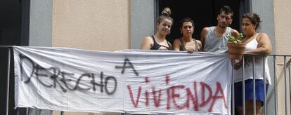 Varios vecinos asomados a un balcón del nuevo edificio ocupado en el centro de Sevilla.