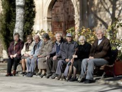 Varios ancianos toman el sol en unos bancos de Olmeda de la Cuesta, Cuenca. EFE/Archivo