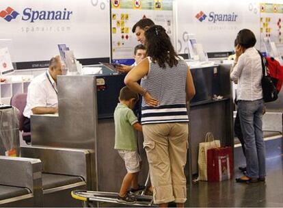 Varios pasajeros de vuelos de Spanair facturan su equipaje para volar con normalidad un día después de la catástrofe aérea ocurrida ayer en Barajas