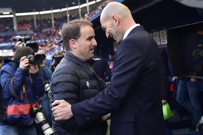 Los estrenadores del Osasuna, Jagoba Arrasate, y del Real Madrid,  Zinedine Zidane, se saludan minutos antes del comienzo del encuentro en el estadio de El Sadar, este domingo en Pamplona.