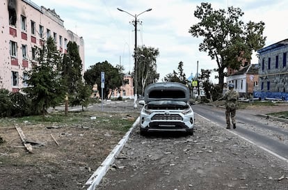 A Ukrainian serviceman patrols a street next to buildings damaged during recent fighting between Ukrainian and Russian forces in the Ukrainian-controlled town of Sudzha, August 16, 2024. 