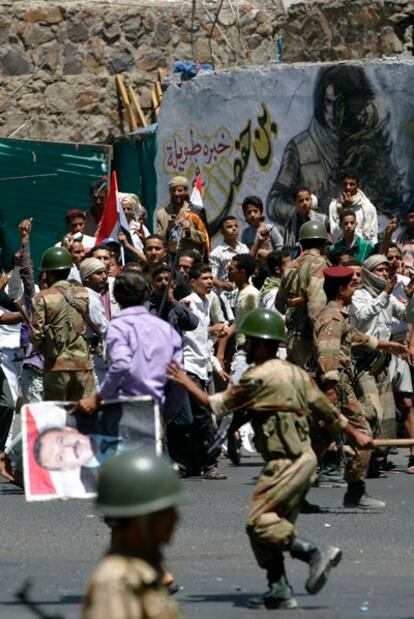 Los soldados contienen a los partidarios del presidente de Yemen, durante los enfrentamientos con los manifestantes antigubernamentales en Taiz.