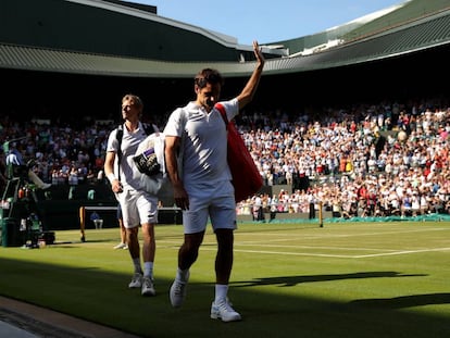 Federer se despide del público de la Pista 1, con Anderson detrás, este miércoles en Wimbledon.