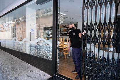 Un empleado cierra la persiana de un bar en el centro de la capital granadina, este martes.