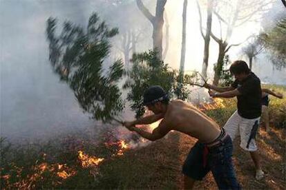 Vecinos de Chiclana intentan controlar el incendio declarado ayer en Las Mogarizas.