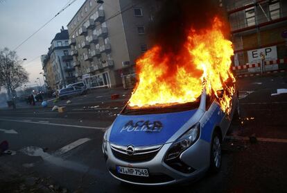 Una patrulla de la Policía alemana arde en llamas en la ciudad de Franfurt, Alemania.