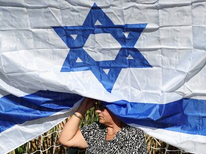 Una mujer sentada debajo de una bandera de Israel, durante una ceremonia en memoria de las víctimas del ataque de Hamás, el 16 de noviembre en el kibutz Gezer.