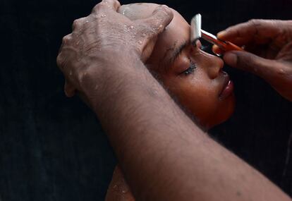 Un monje novicio de Sri Lanka durante una ceremonia en el pueblo de Eheliyagoda en la que le afeitan las cejas como ritual de acceso al sacerdocio.