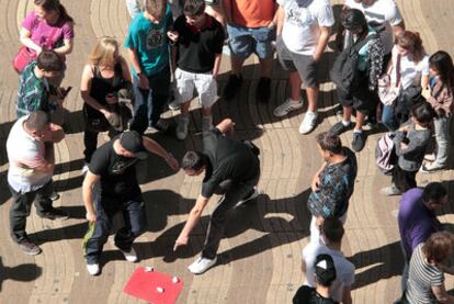 Un grupo de trileros rodeado de turistas, el pasado viernes, en La Rambla de Barcelona.