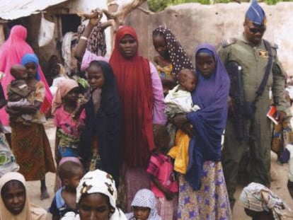 Un soldat amb dones i nens alliberats de Boko Haram.