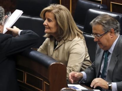 La ministra de Empleo, F&aacute;tima B&aacute;&ntilde;ez, hablando con el secretario de Estado de la Seguridad Social, Tom&aacute;s Burgos, y, a la derecha, el ministro del Interior, Juan Ignacio Zoido.