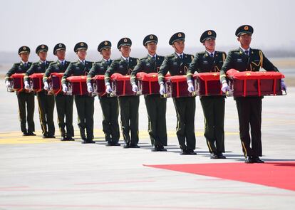 Los guardias de honor chinos llevan ataúdes que contienen los restos de diez soldados chinos muertos durante la Guerra de Corea de 1950-53, que han sido devueltos por Corea del Sur, en el Aeropuerto Internacional Shenyang Taoxian, al noreste de China.