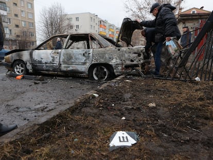 Local residents inspect a damaged car hit by shelling, what local authorities called a Ukrainian military strike, in the Belgorod Region, Russia March 19, 2024.