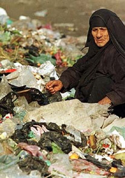 Una mujer iraquí escarba entre la basura en el distrito de Kadamiya.