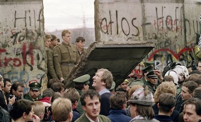 Ciudadanos de Berlín Oeste se amontonan delante del muro el 11 de noviembre ante la mirada de guardias de Berlín Este.