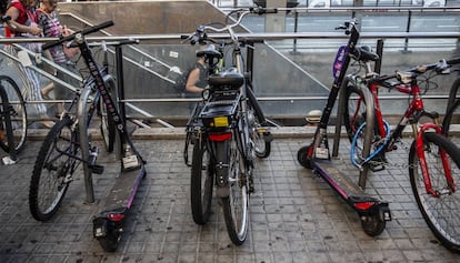 Patinetes de una de las empresas sancionadas aparcados junto a bicicletas