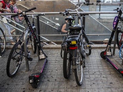 Patinetes de una de las empresas sancionadas aparcados junto a bicicletas