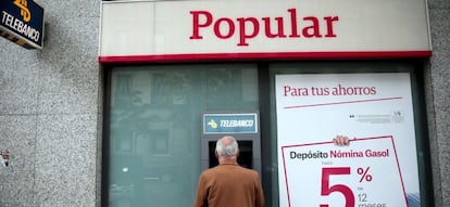 Un hombre sacando dinero de un cajero de Banco Popular