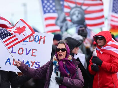 Una mujer ondea una bandera de Estados Unidos y Canadá la mañana del miércoles en Adelanto (California).