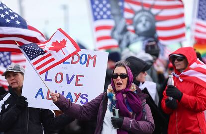 Derecha en EEUU: Una mujer ondea una bandera de Estados Unidos y Canadá
