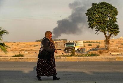 Una mujer camina tras el bombardeo turco en la ciudad de Ras al-Ain en la provincia siria de Hasakeh. El presidente Recep Tayyip Erdogan anunció el inicio del ataque en Twitter, etiquetándolo como "Operación Primavera de Paz".