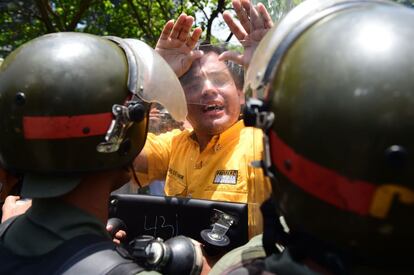 Miles de opositores se movilizaban este miércoles en Caracas y otras ciudades para exigir elecciones generales, arreciando su ofensiva contra el presidente Nicolás Maduro. En la imagen, un opositor del presidente venezolano se enfrenta a unos policías, en Caracas.