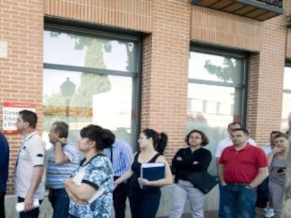 Un grupo de personas hace cola en una oficina de empleo en Alcalá de Henares.